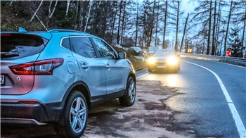 Ein silberner Nisan steht am Straßenrand und unter dem Wagen ist ein Pulver verstreut.