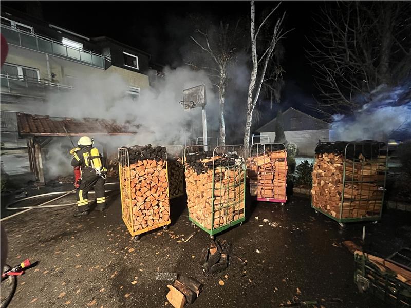 Feuer in Langelsheim: Holzunterstand steht in Flammen Die Einsatzkräfte löschten das brennende Holz und schoben die Wagen aus dem Gefahrenbereich. Foto: Feuerwehr Langelsheim