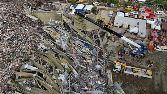 Die Einsatzkräfte suchen unter anderem mit einem Kran in den Abfall-Massen.