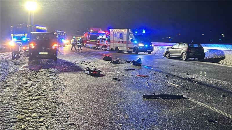 Mehrere Fahrzeuge stehen abends auf der Autobahn, darunter Rettungswagen und Unfallfahrzeuge. Davor ein Trümmerfeld.