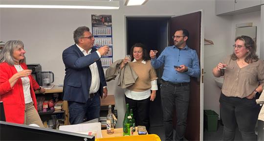 Das Foto zeigt ein paar Menschen, die sich zuprosten.