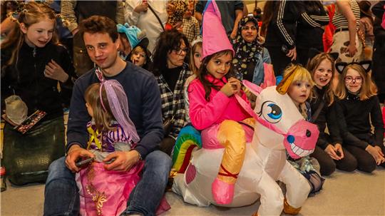 Kinderfasching in der Clausthaler Stadthalle: Verkleidete Kinder haben Spaß, besonders auffällig ist eine Prinzessin auf einem aufblasbaren Einhorn.