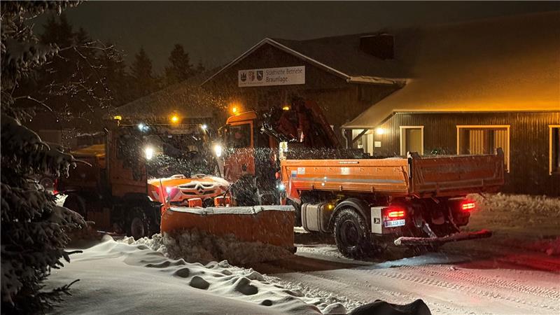 Das Foto zeigt zwei Schneepflüge, die vor dem verschneiten Sitz der Städtischen Betriebe in Braunlage stehen.