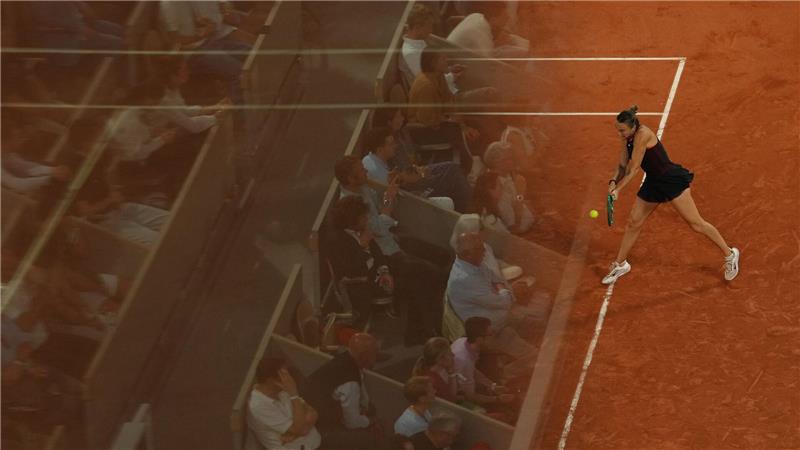 Die Fans spiegeln sich in einer Glaswand bei den French Open, während Aryna Sabalenka eine Rückhand gegen Naomi Osaka spielt.
