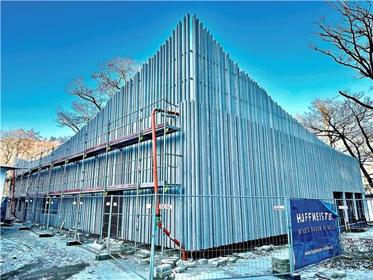 Die Fassade des Erlebniskontors ist aus unzähligen Lärchenhölzern zusammengestellt, der Plan dafür, den Holger Kolb auf dem linken Bild studiert, sieht aus wie ein Puzzlespiel. Foto: Schlegel