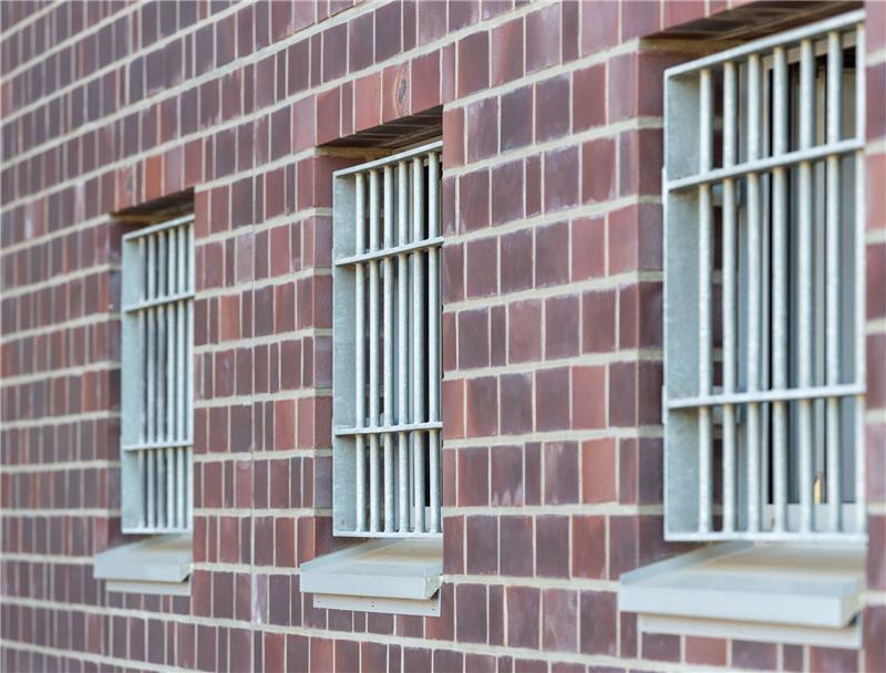 Die Fenster einer Justizvollzugsanstalt sind vergittert.