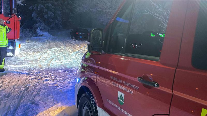 Das Foto zeigt ein Feuerwehrfahrzeug und ein Auto im Schnee.