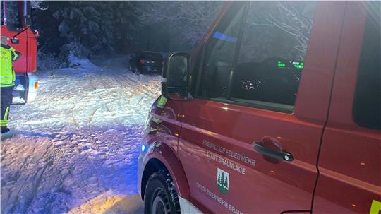 Das Foto zeigt ein Feuerwehrfahrzeug und ein Auto im Schnee.