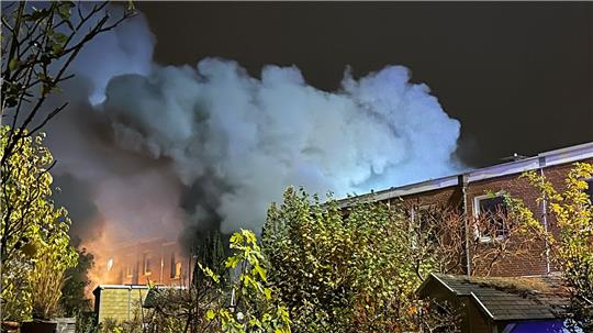 Auf dem Bild ist eine graue Rauchwolke zu sehen, die aus einem Wohnhaus aufsteigt.