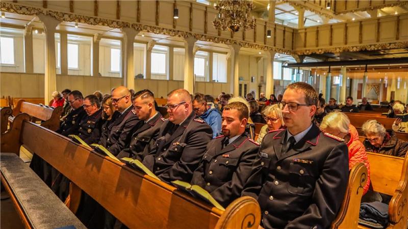 Größte Holzkirche Deutschlands brennt im Juli Das Foto zeigt Besucher beim ersten Gottesdienst in der Marktkirche nach dem Brand. In der vorderen Reihe sitzen Feuerwehrleute.