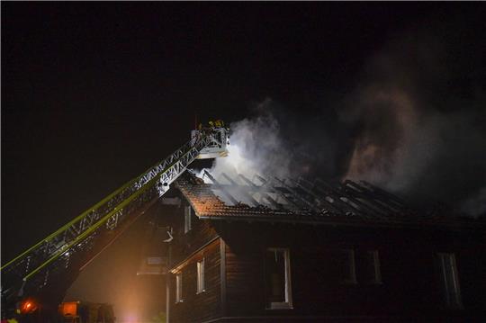 Die Feuerwehr löscht den Brand im Dachstuhl eines Hauses nach einem Blitzeinschlag.