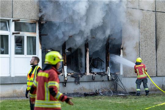 Die Feuerwehr löscht den Brand in der Flüchtlingsunterkunft.