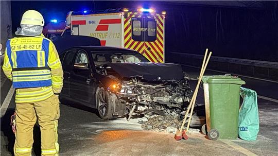 Die Feuerwehr sichert auslaufende Betriebsstoffe, im Hintergrund der Unfallwagen
