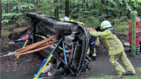 Die Feuerwehrleute müssen eine Frau aus dem Fahrzeug befreien.