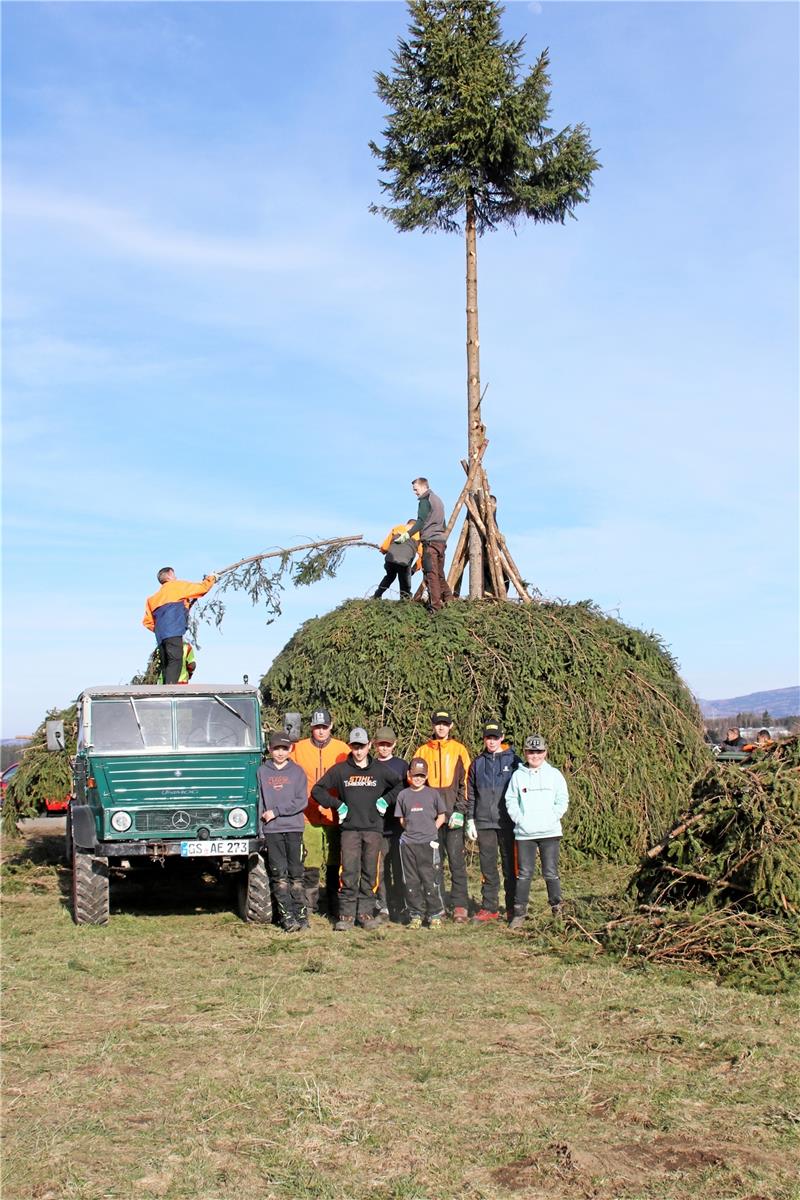 Oberharzer wollen die Tradition aufrecht erhalten Die Fichte steht am Dienstagabend bereits auf der Bockswieser Höhe. Nun wird der Meiler Schicht für Schicht mit der Hand gebaut. Die nächste Generation wird schon angelernt. Auch auf der Rose in Altenau ist das erste Brennmaterial bei Rüdiger Kail angekommen (rundes Bild). Fotos: Fricke