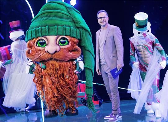 Die Figur «Klaus Claus» steht in der Prosieben-Show „The Masked Singer“ auf der Bühne neben Moderator Matthias Opdenhövel.