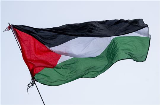 Die Flagge von Palästina wird bei einer propalästinensischen Kundgebung geschwenkt. 
Bei derartigen Kundgebungen kam es vor allem in den ersten Wochen nach dem Massaker immer wieder zu Zusammenstößen mit der Polizei.