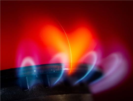 Die Flamme eines Gasherdes brennt in einer Küche.