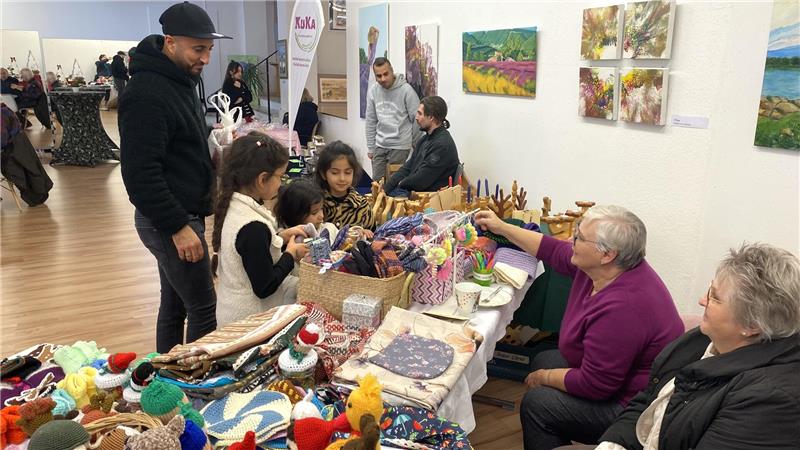 An einem Stand im Mehrgenerationenhaus werden gestrickte Dinge verkauft.