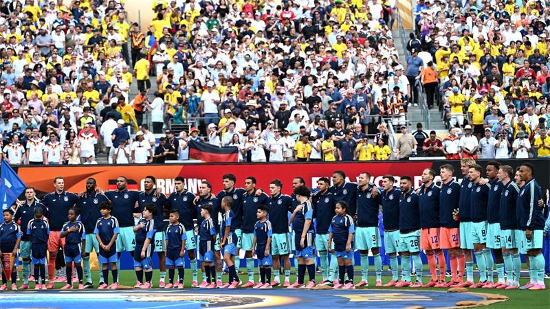 Die Fußball-Nationalmannschaft steht beim Abspielen der Nationalhymne am Mittelkreis. 