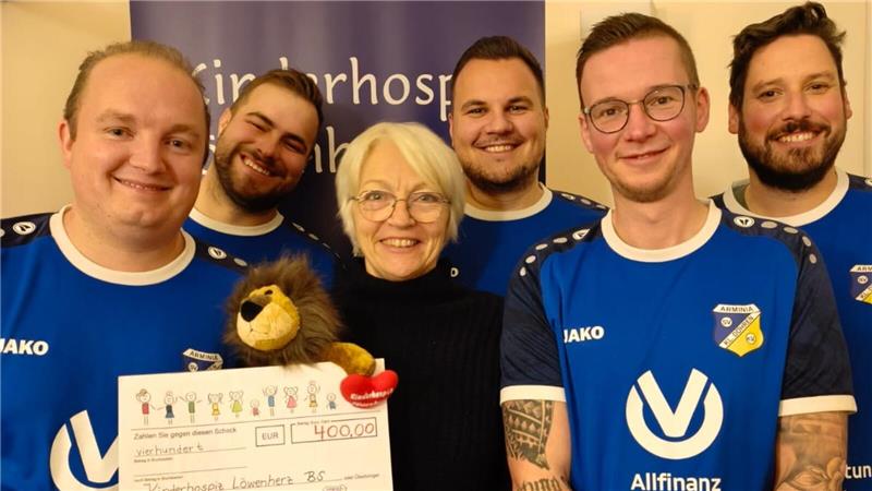 Gruppe von fünf Personen in blauen Trikots, eine Person hält einen großen Scheck mit der Aufschrift 'Kinderhospiz Löwenherz' und einem Betrag von 400,00 Euro.