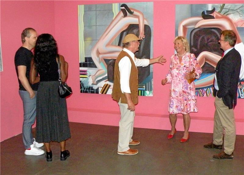 Die Gemälde von Kristina Schuldt (siehe kleines Foto) haben ihre ganz eigene Ästhetik und regen die Besucher der Vernissage (großes Bild) zu lebhaften Diskussionen an.  Fotos: Habel