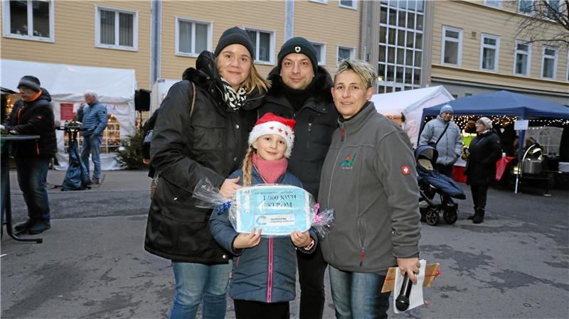 Familie Creutzig hat das schönste Weihnachtshaus im Oberharz Die Gewinnübergabe erfolgt beim weihnachtlichen Standtreiben der Vereine im Innenhof der TU Clausthal. Silvia Hoheisel (r.) überreicht den Stromgutschein an Familie Creutzig. Foto: Neuendorf