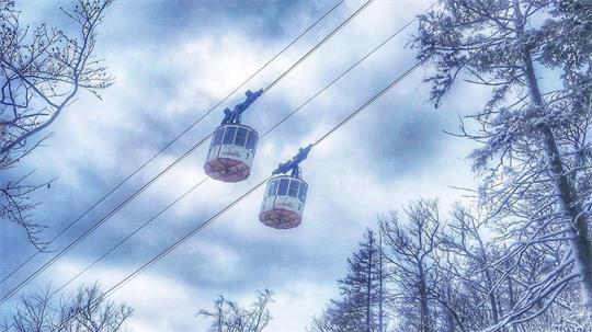 Das Foto zeigt zwei Gondeln einer Seilbahn.