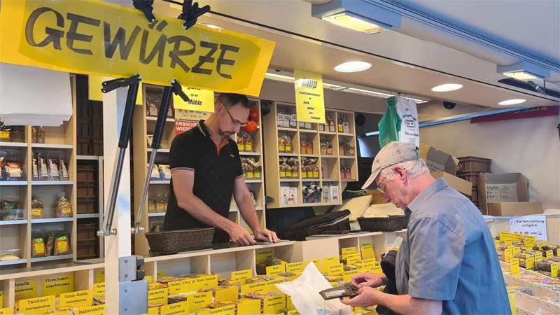 Ein Mann kauft etwas am Gewürzstand.