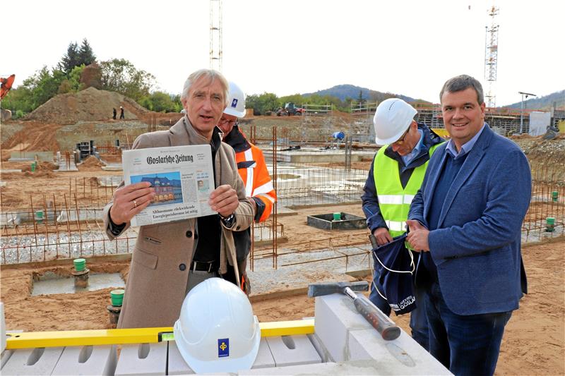 Die Goslarsche Zeitung des Tages geht mit hinein in die Zeitkapsel, die Markus Kellner (l.), Geschäftsführer von Depenbrock, und Landrat Dr. Alexander Saipa gemeinsam im Grundstein einmauern. Foto: Kaspert