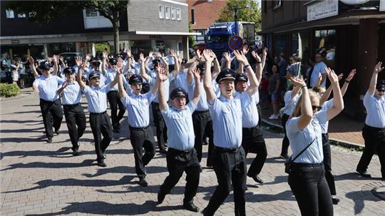 Die Hände zum Himmel: Von dort scheint die Sonne am Sonntag mit Macht, als Langelsheims Feuerwehr durch die Stadt zieht.