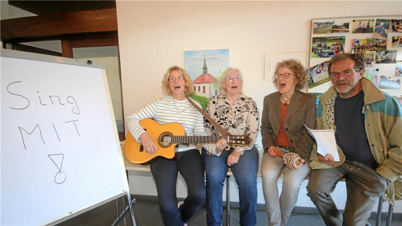 Nachbarschaftshilfe und Dorfgemeinschaft: Engagement im Nordharz Vier Personen sitzen nebeneinander, eine spielt Gitarre, daneben steht ein Flipchart mit der Aufschrift 'Sing MIT !'