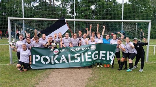 Die Hahndorferinnen feiern ihren Erfolg. Sie gewinnen mit einer geschlossenen Teamleistung verdient gegen den Favoriten SC 18 Harlingerode. Trainer Danny Czwojdrak schwenkt die schwarz-weiße Flagge.