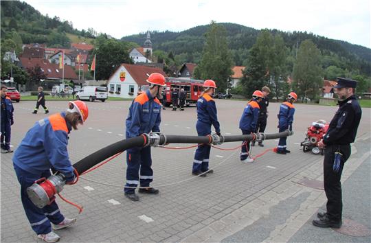 Die Helfer Hendrik Wolf und Arne Niestroj (v. li.) begutachten die Löschübung der Mitglieder der Jugendfeuerwehr. Foto: Hohaus