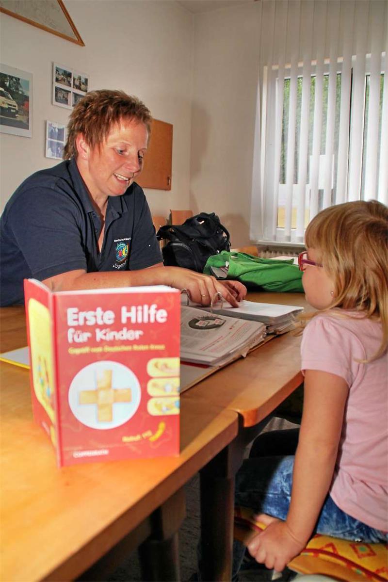 Die JRK-Leiterin Angelika Eilert erklärt der sechsjährigen Amelie die Aufgaben und Tätigkeiten des Deutschen Roten Kreuzes.  Foto: Leifeld