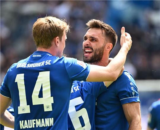 Die Karlsruher Mikkel Kaufmann (l) und Fabian Schleusener bejubeln den Treffer zum 2:0 durch Fabian Schleusener.