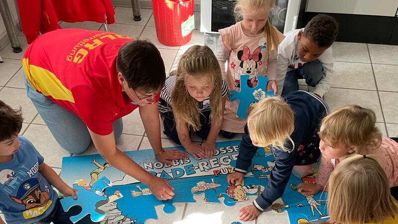 Kita-Kinder zu Besuch bei der DLRG Clausthal-Zellerfeld Die Kinder der Kita St. Salvatoris puzzlen die Baderegeln zusammen.