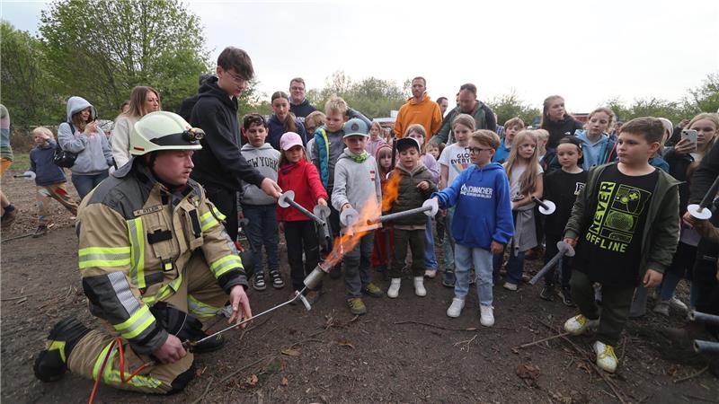 Die Kinder dürfen das Osterfeuer mit Feuerwehr-Hilfe anzünden.