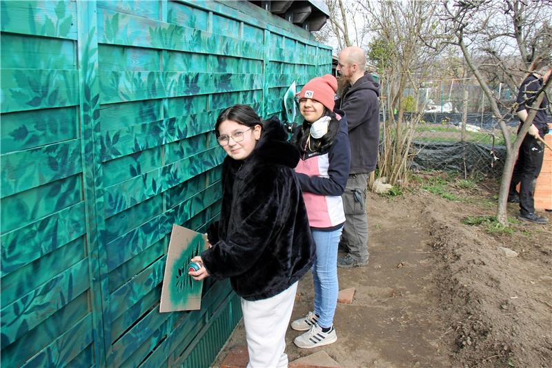 Bad Harzburg: Ein Dschungel im Schrebergarten Die Kinder sprühen mithilfe einer Schablone kreative Graffiti an die Wand. Foto: Jenzora