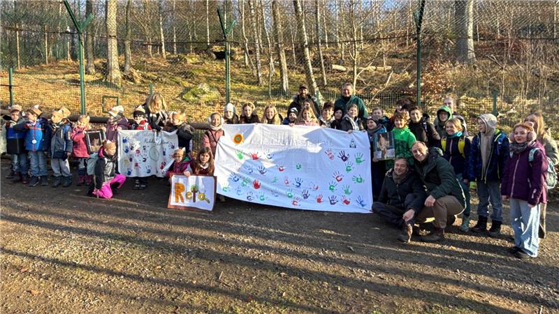 Eine große Gruppe Kinder zeigt die Transparente mit ihren Handabdrücken und zwei Luchspfotenstempeln.