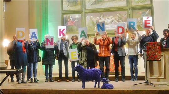 Die Kirchenvorstände stehen in einer Reihe, jeder hält ein Schild mit einem Buchstaben – zusammen ergeben diese die Worte: "Danke Andre".