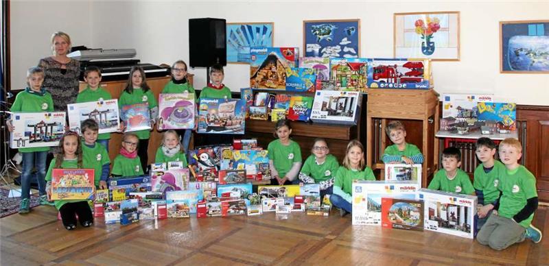Die Klasse 3a mit ihrer Klassenlehrerin Britta Busse präsentiert ihre Gewinne und die neuen T-Shirts.  Foto: Hohaus
