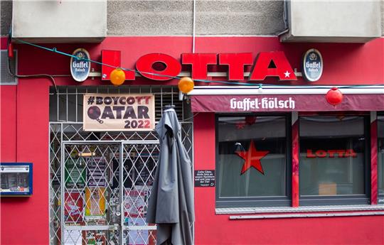 Die Kneipe Lotta in der Kölner Südstadt boykottiert die Fußball-WM-Spiele in Katar und hat über dem Eingang ein Banner aufgehängt.