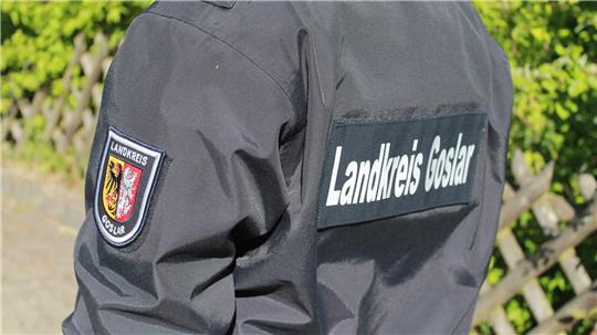 Rückenansicht einer Person in schwarzer Uniform mit Aufnähern und Schriftzug 'Landkreis Goslar'