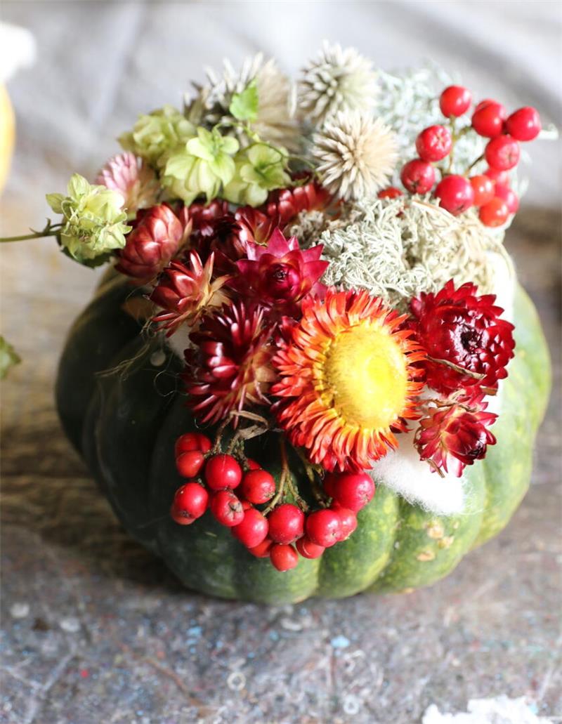 Diese Vereine im Harz setzen auf Natur und Gemeinschaft Grüner Kürbis als Vase mit verschiedenen getrockneten Blumen und roten Beeren auf einem Steinboden
