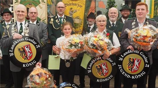 Die Landkreiskönige im Überblick (v.l.) König Alexander Just, Landkreislichtkönigin Thomke Anna Luise Spahn, Landkreiskönigin Dagmar Graf, Landkreisjugendkönig Benedict Klohr. Im Hintergrund zu sehen sind die Vorsitzenden und Fahnenträger der Kreisschützenverbände Goslar, Oberharz und Bad Gandersheim.
