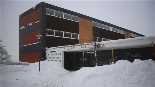 Das Foto zeigt ein verschneites Schulgebäude.