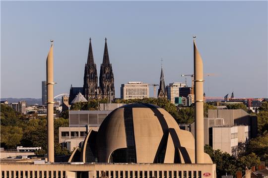Die Minarette der Zentralmoschee der DITIB ragen vor den Türmen des Kölner Doms in den Himmel.