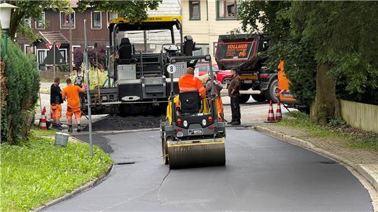 Die Mitarbeiter eines Tiefbauunternehmens sind derzeit dabei, die Straße „Am Steinfeld“ neu zu asphaltieren.