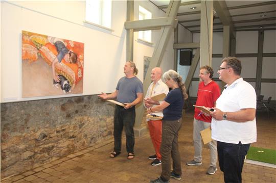 Die Mitglieder der Jury (von links) Detlef Kiep, Klaus Müller, Meike Hullen, Thomas Velte und Wolfgang Langer schauen sich ein Kunstwerk an, das in der Rathausscheune ausgestellt ist. Foto: Eggers